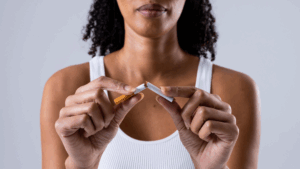 Zoom sur une jeune femme cassant en deux une cigarette avec ses doigts